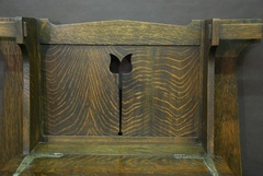 Floral cut-out on back panel of book-matched quarter-sawed oak of spectacular grain above pewter strap hardware. 